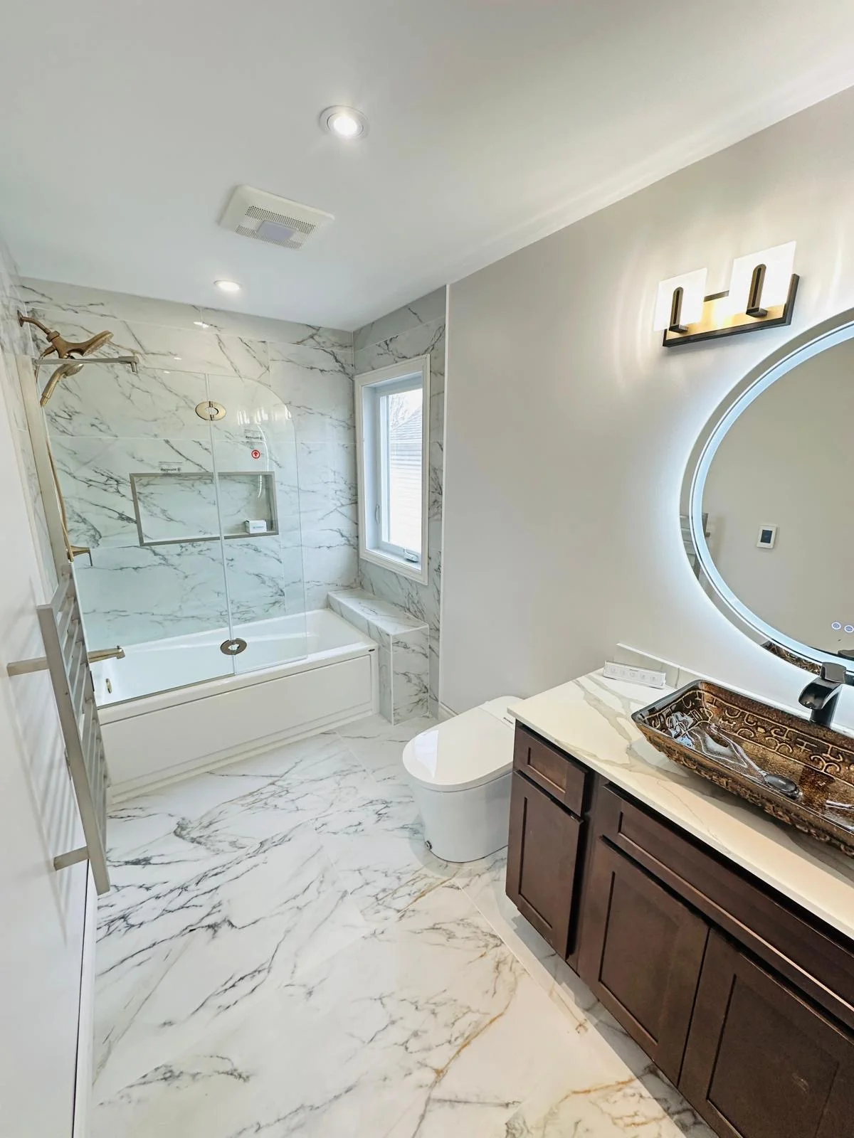 Luxury marble bathroom with tub and glass shower enclosure