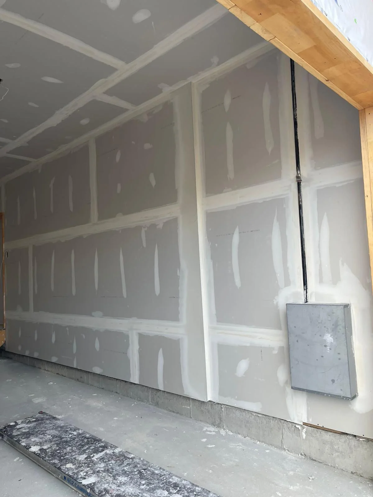 Garage wall taped and mudded around an electrical panel