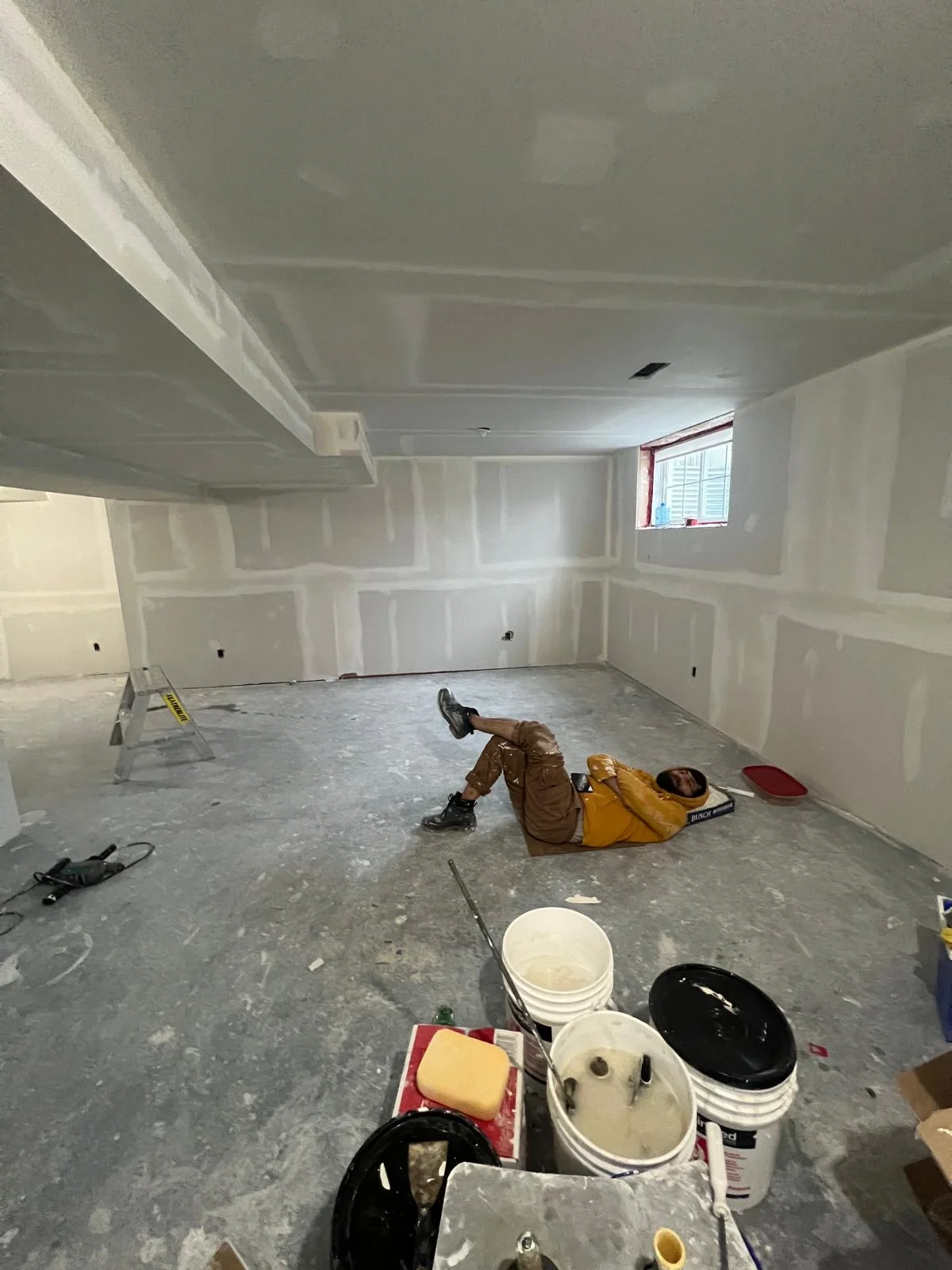 MLH Drywall Taping Painting Inc crew member on a basement job site in Scarborough