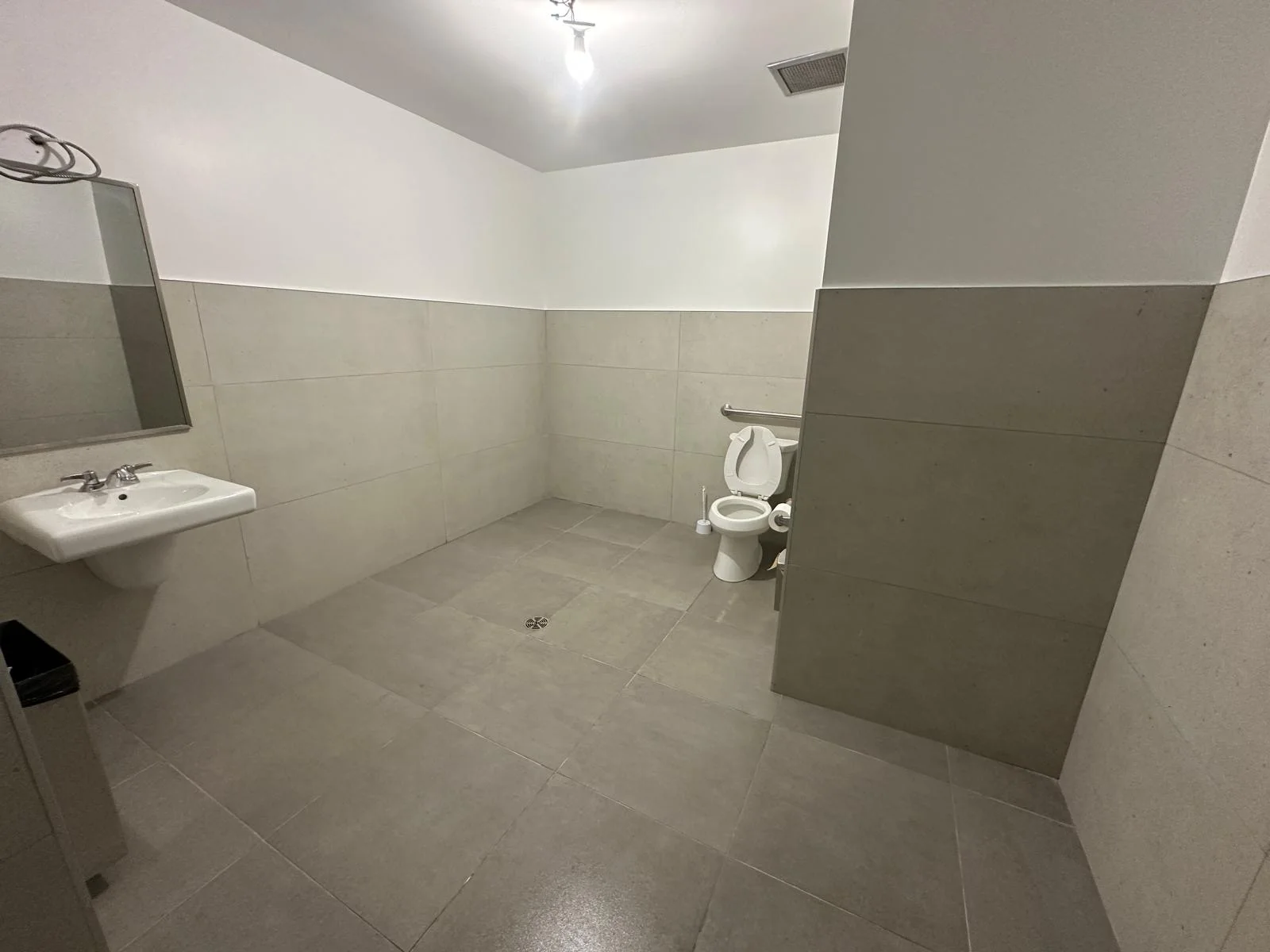 Commercial accessible washroom with tile floor and walls