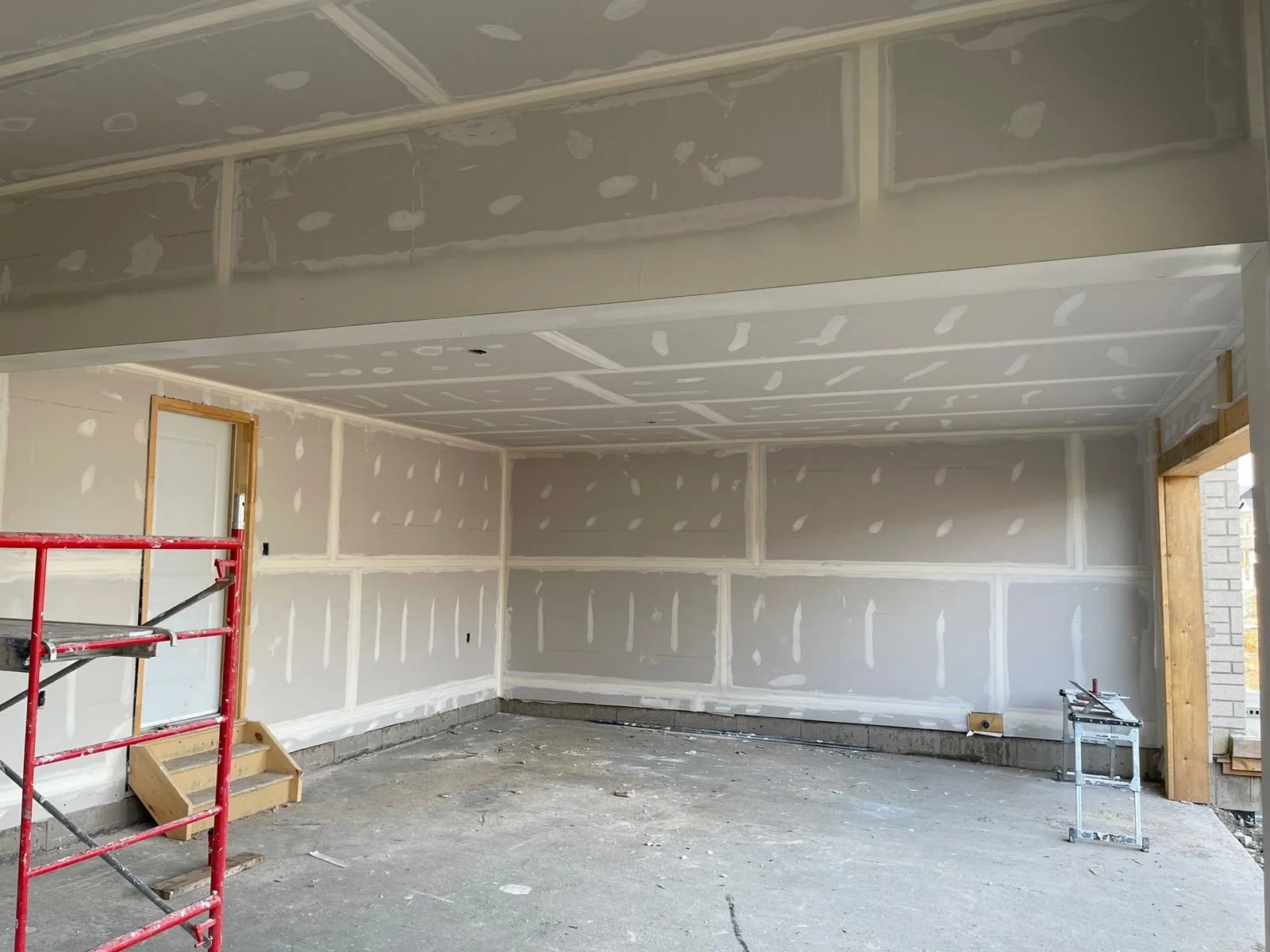 Garage walls and ceiling with taped drywall seams and first-coat mud spots